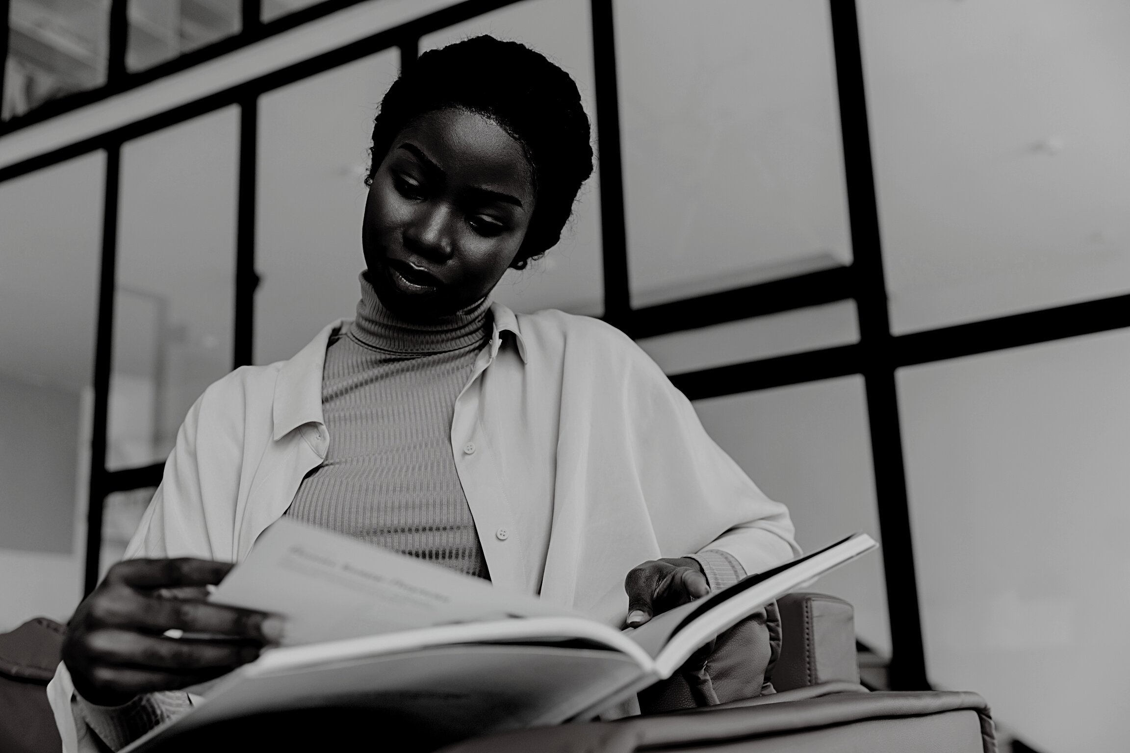 Concentrated Young African Woman Reading Magazine